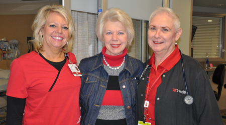 Mary Siereveld, center, prepares to deliver gifts to patients on the neuroscience floor at the UC Medical Center. At left, Lisa Bowman, RN, Nurse Manager on 4 West; at right, Carrie Roark, Medical Assistant at the Gardner Center for Parkinson's Disease and Movement Disorders. Photos by Cindy Starr.